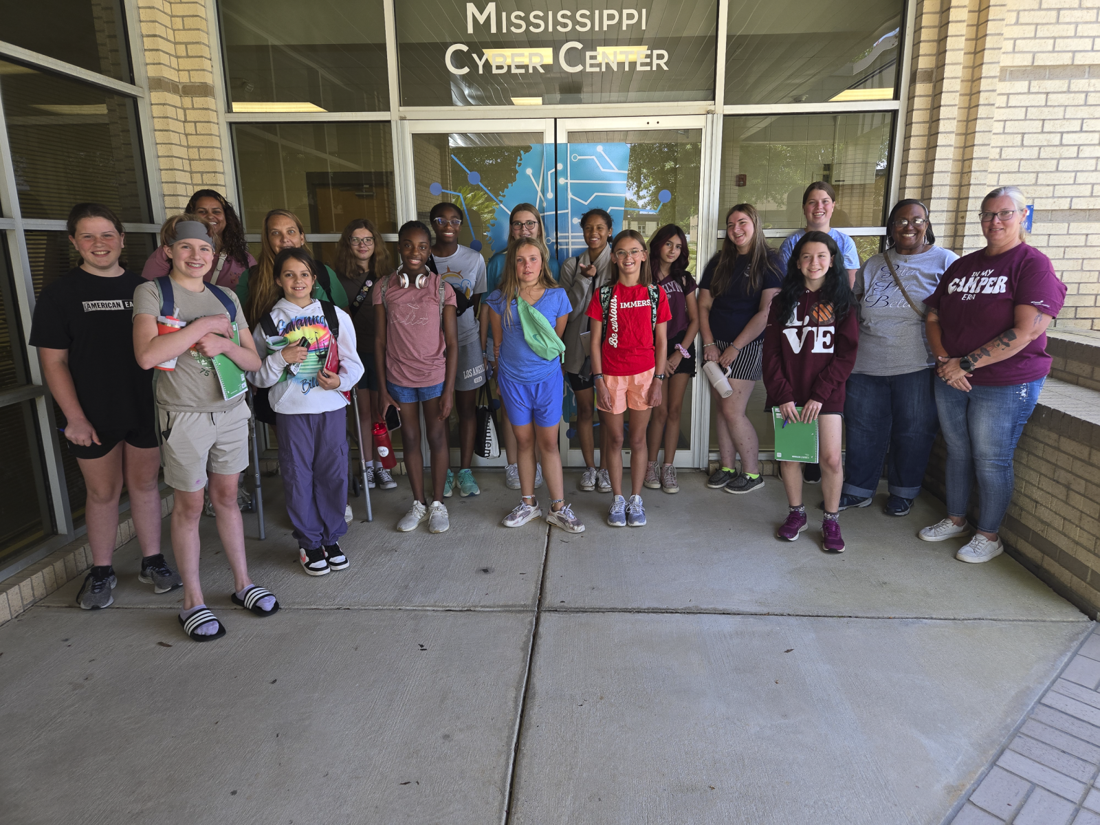 A group of Girl Scout cyber event participants pose in front of the Mississippi Cyber Center