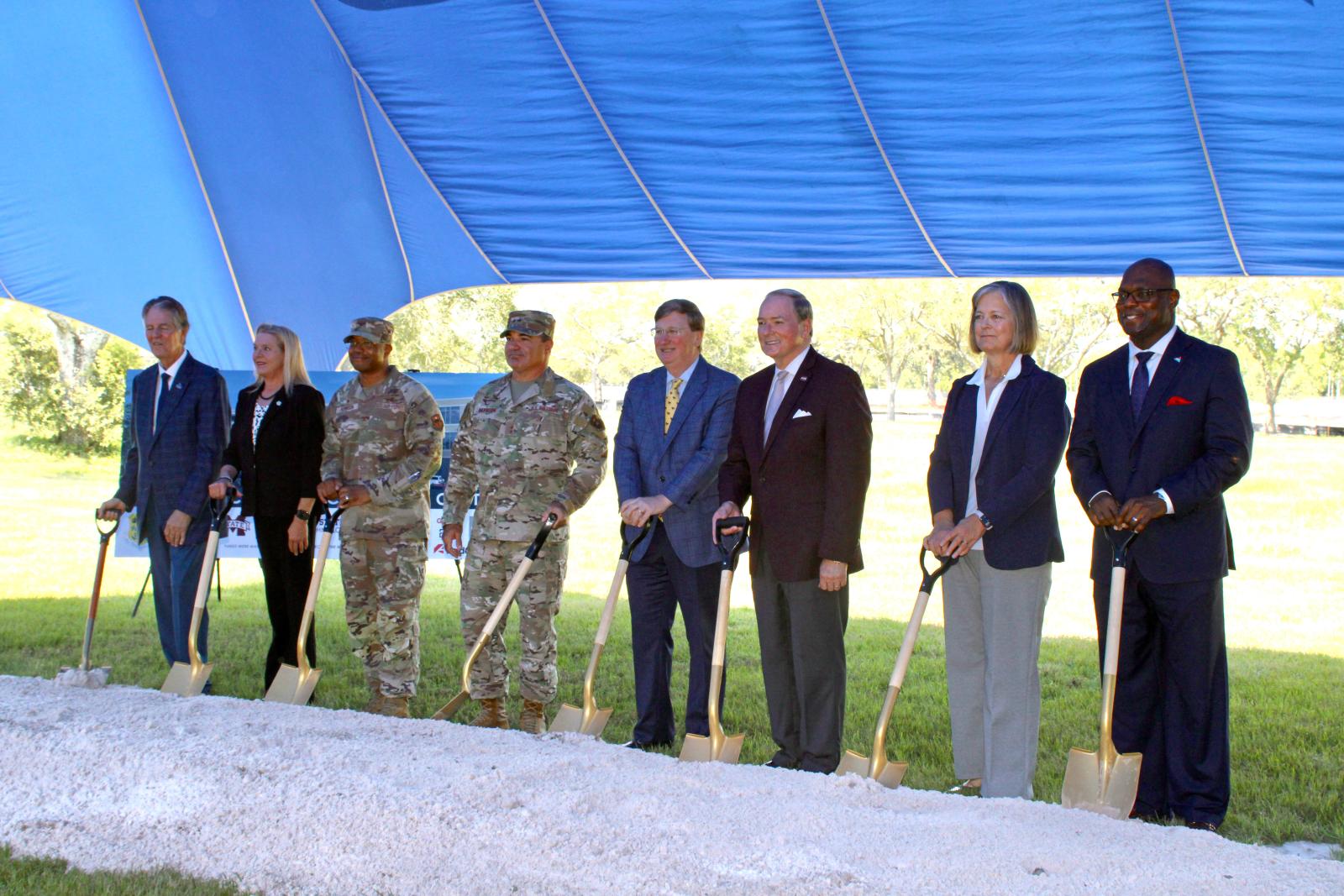 Officials hold shovels during a ceremonial groundbreaking